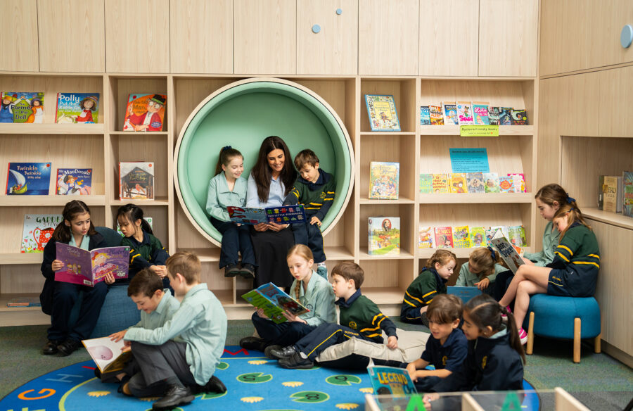 Kylie reading with students in Library