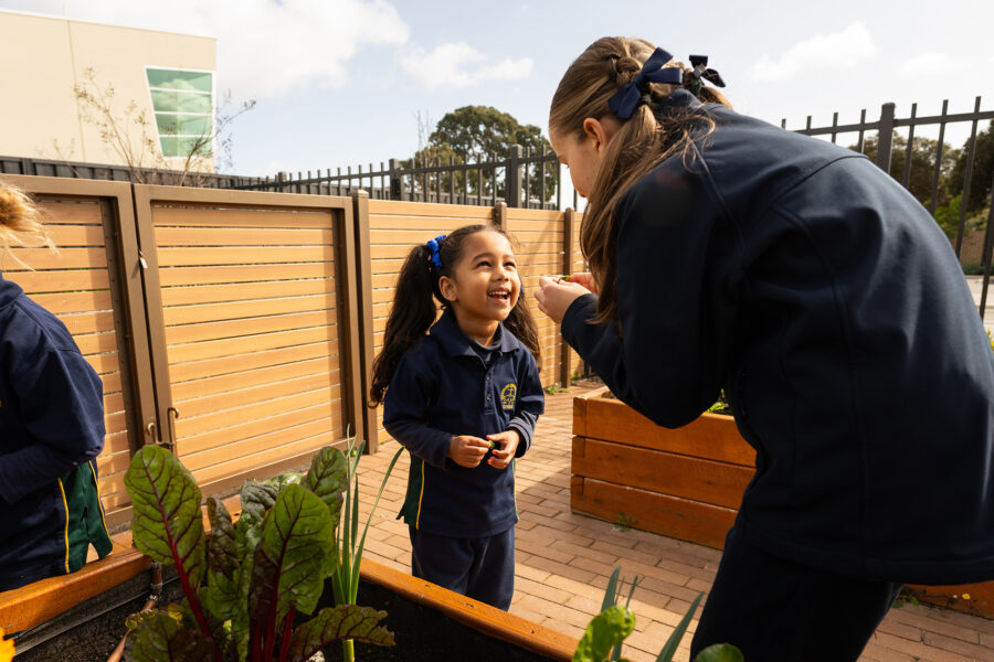 Older student and younger student enjoying Garden