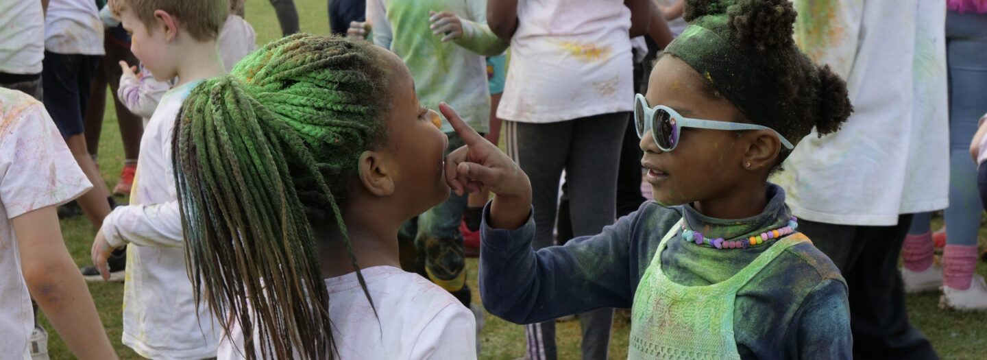 Two girls looking at each other after the colour fun run